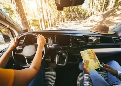 View from inside a crossover on a forest road in Australia with a driver and a passenger holding a map